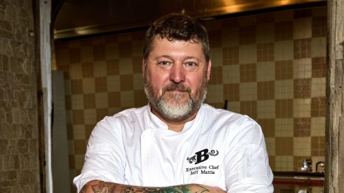 Headshot of chef Jeff in a white coat in the kitchen