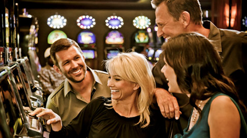 2 men and 2 women playing casino slots
