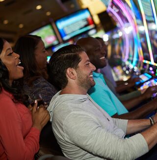 group of friends at a slot machine cheering