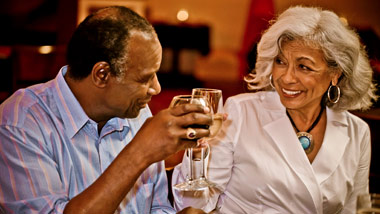 Older couple toasting while dining